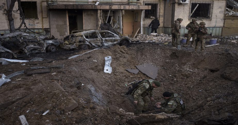 Ukrainian bomb squad inspect the site of an explosion after bombing in Kyiv, Ukraine, Sunday, March 20, 2022.