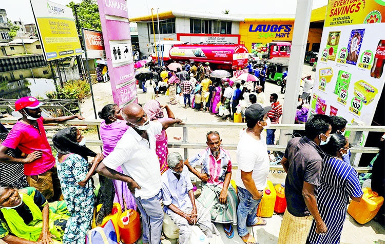 People stand in a long queue to buy kerosene oil for kerosene cookers amid a shortage of domestic gas due to country's economic crisis, at a fuel station in Colombo, Sri Lanka on Monday.