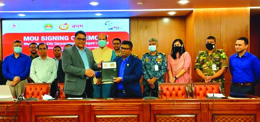 Mohammad Abdul Hamid Mia, Chief Revenue Officer of Dhaka North City Corporation (DNCC) and Rahel Ahmed, CEO of Nagad, exchanging document after signing an agreement at Nagar Bhaban in the capital recently. Senior executives from both sides were present.
