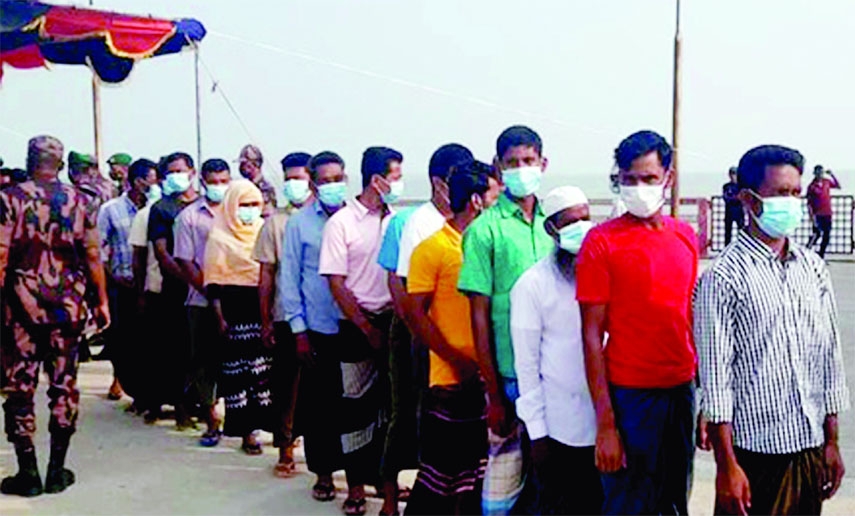 People are seen in a queue at Teknaf Jettyghat in Cox's Bazar on Wednesday as 41 stranded Bangladeshis returned home from Myanmar through flag meeting.