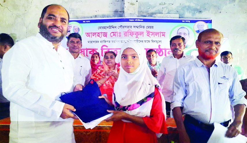 BORHANUDDIN (Bhola): Rafiqul Islam, Mayor, Borhanuddin Municipality distributes school dresses among the poor students of Borhanuddin Girls Secondary School in Borhanuddin Upazila on Wednesday.