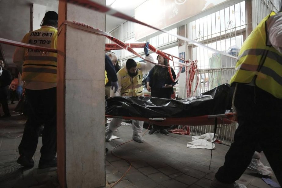 A body is removed from the site where a gunman opened fire in Bnei Brak, Israel, Tuesday, March 29, 2022.