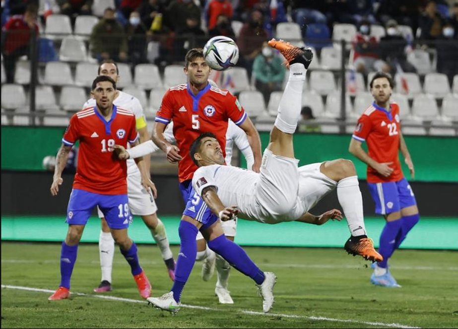 Uruguay's Luis Suarez (center) does a back kick to score his side's opening goal against Chile during a qualifying soccer match for the FIFA World Cup Qatar 2022 at San Carlos de Apoquindo stadium in Santiago, Chile on Tuesday. AP photo