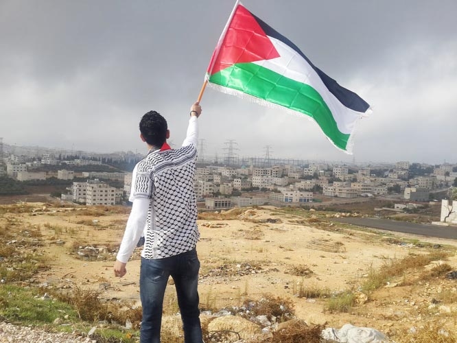 A Palestine youth waving flag despite death.