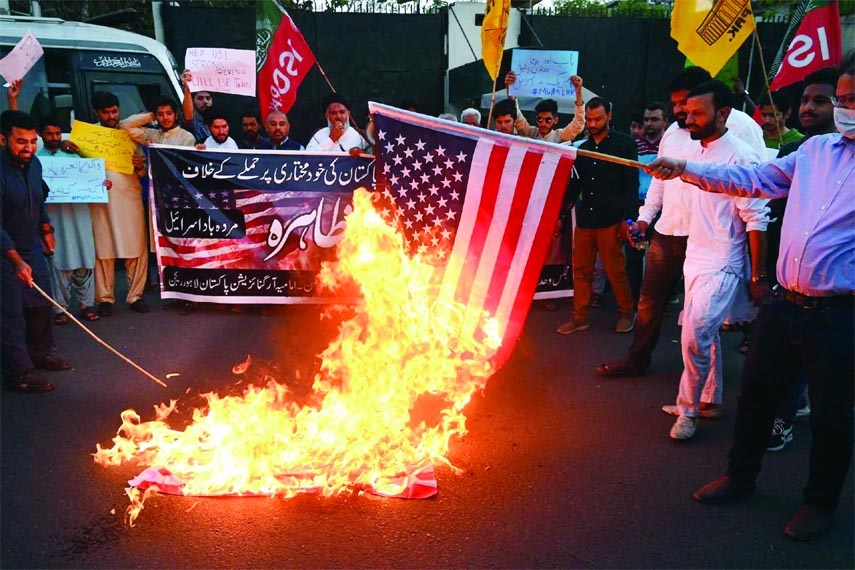 Shia Muslim demonstrators from the Majlis Wahdat-e-Muslimeen Pakistan political organisation burn US flags during a protest in Lahore on Friday.