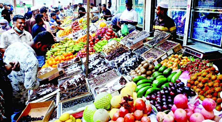 A vendor sells fruits on a street market at Purana Paltan in the capital on Saturday. Local and imported fruits have become more costly ahead of Ramzan. NN photo