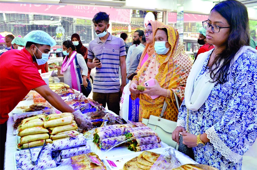 Customers stand in front of an Iftar stall at Bailey Road in the capital on Monday.