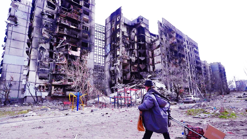 A local resident walks near an apartment building destroyed during Ukraine-Russia conflict in the southern port city of Mariupol, Ukraine on Sunday.