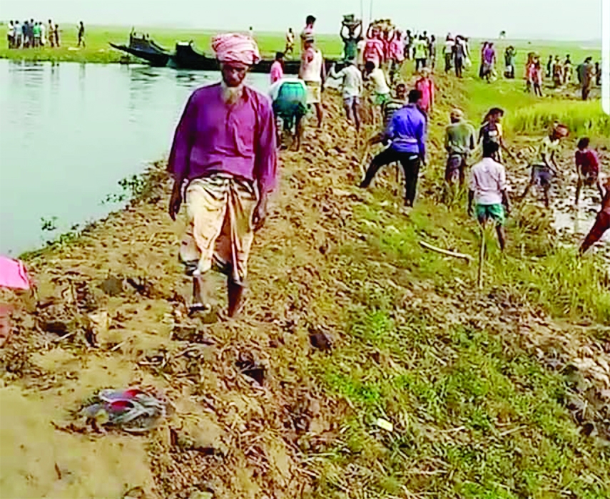 People of Itna upazila of Kishoreganj are seen repairing a haor flood protection embankment since a crack was developed on its surface following flash floods, caused by heavy rains in the upstream.