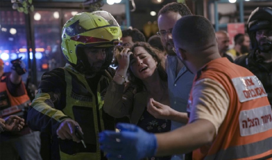 woman reacts at the scene of a shooting attack In Tel Aviv, Israel, Thursday, April 7, 2022. Israeli health officials say two people were killed and at least eight others wounded in a shooting in central Tel Aviv.