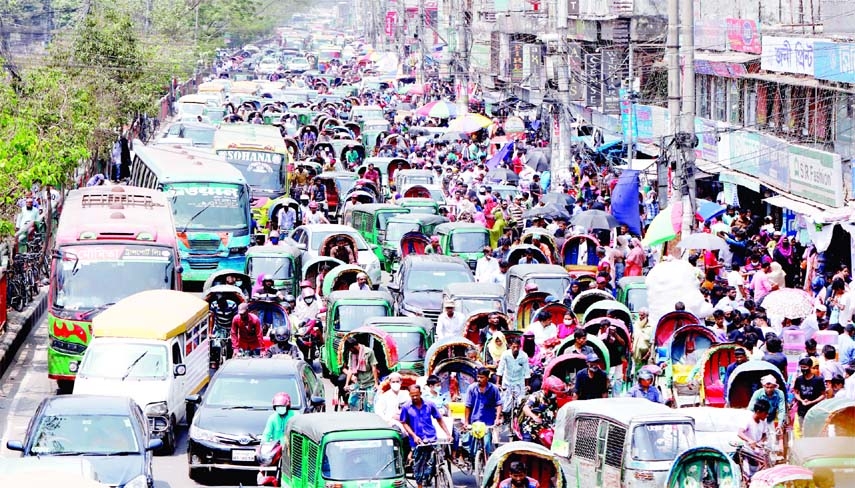 Hundreds of vehicles get clogged with heavy traffic congestion in front of markets ahead of Eid even on holiday. This photo was taken from Mirpur Road New Market foot over bridge on Saturday.