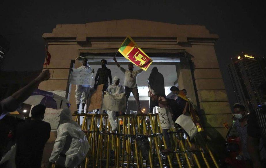 Sri Lankans shout anti government slogans blocking the entrance to president's office during a protest in Colombo, Sri Lanka, Monday, April 11, 2022.