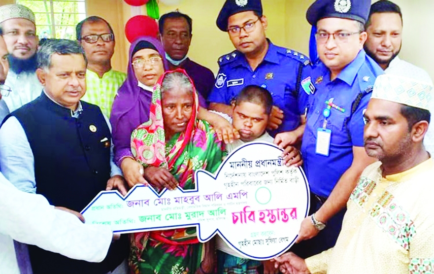 MADHABPUR (Habiganj): State Minister for Aviation and Tourism Md Mahbub Ali hands over the keys of house to landless Safia and her disabled son Jamil in Santoshpur Village at Madhabpur Upazila on Friday.