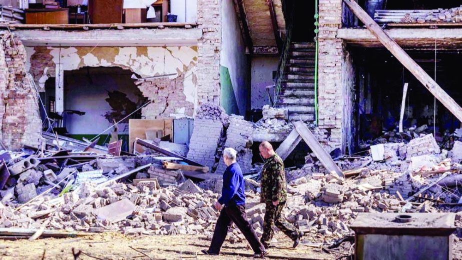 People walk past a building with a collapsed facade at the Vizar company military-industrial complex, after the site was hit by overnight Russian strikes, in the town of Vyshneve, southwestern suburbs of Kyiv, Ukraine on Friday. Agency photo