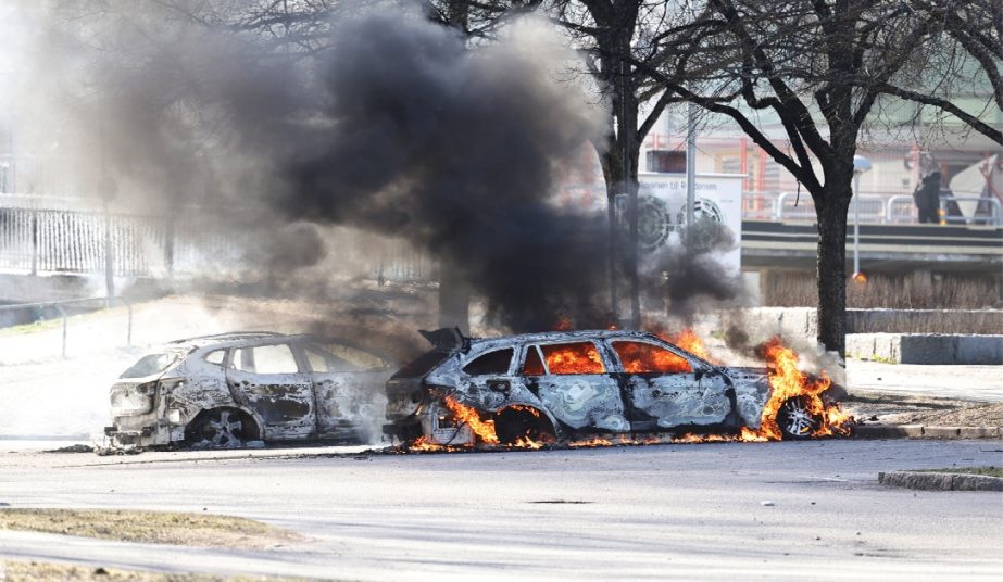 Two cars are burn in a parking lot during a riot in Norrkoping, Sweden, Sunday, April 17, 2022.