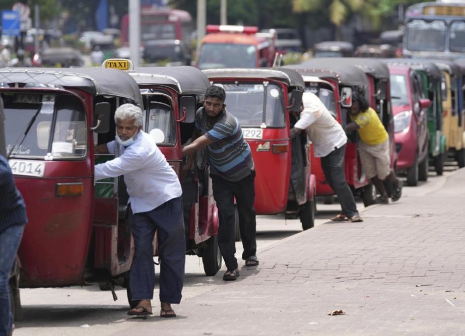 ri Lankan auto rickshaw drivers queue up to buy petrol near a fuel station in Colombo, Sri Lanka, Wednesday, April 13, 2022.