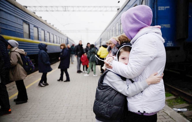 A woman hugs a child as a train prepares to leave the main railway station in Zaporijia, southern Ukraine on Sunday.