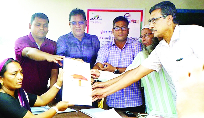 SAGHATA (Gaibandha): Jahangir Kobir, Chairman, Upazila Parishad and Sarder Mustafa Shaheen, UNO, Saghata Upazila hand over documents and key of houses among the landless people at Badinapara Village on Monday.