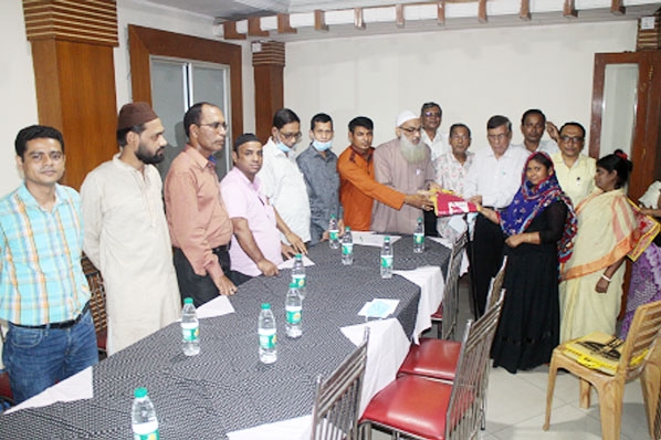 Principal Dr Abdul Karim, Chairman of Bishwajanin Shanti Sangha, distributing Iftar packets among the helpless women of the society on the premises of Station Road office recently. Leaders of the Sangha were also present on the occasion.