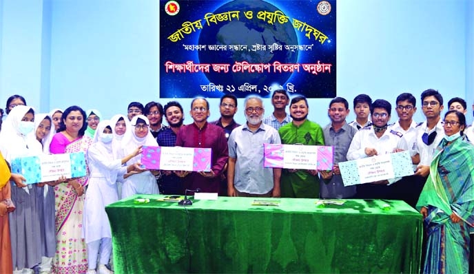 DG of National Science and Technology Museum Munir Chowdhury poses for a photo session with students at telescope distribution on the museum premises in the city on Thursday.