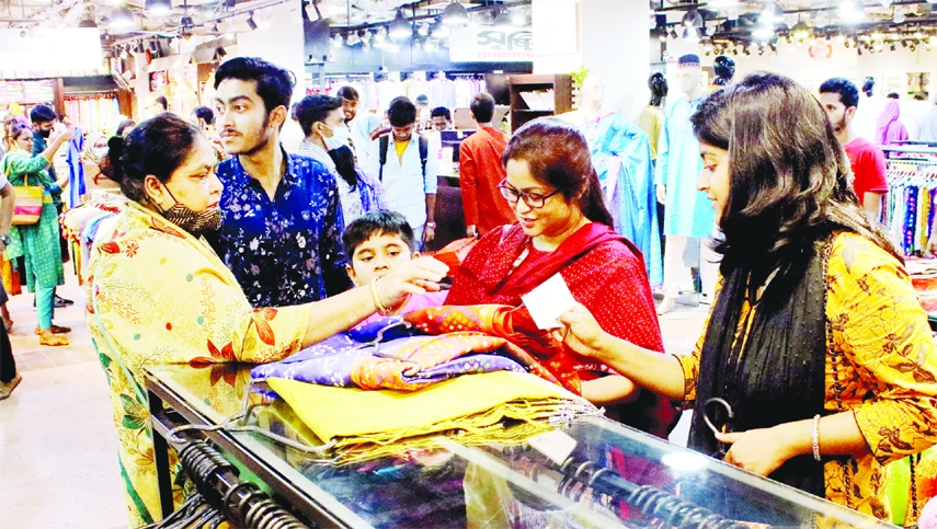 Customers are seen busy with browsing dresses in city's Basundhara city shopping mall on Thursday as part of purchasing during the last moments of Eid.
