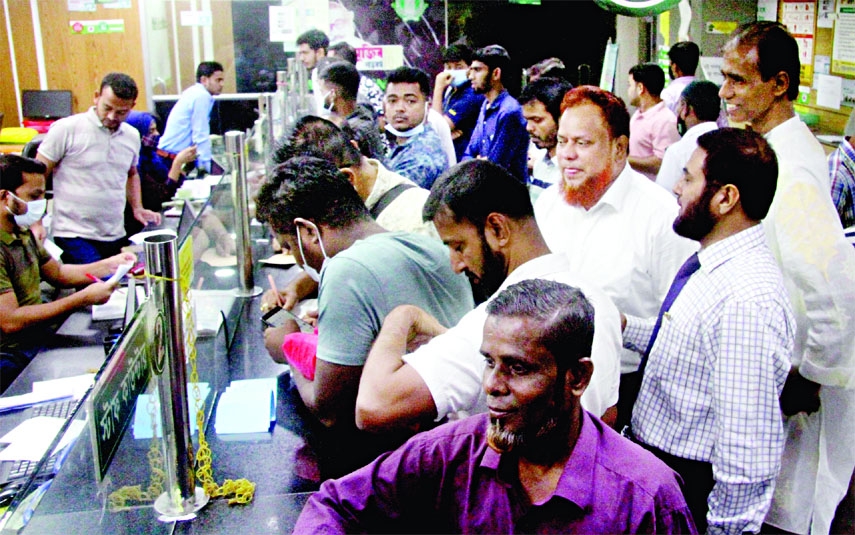 Clients swarm in front of cash counters at a bank branch on Saturday.