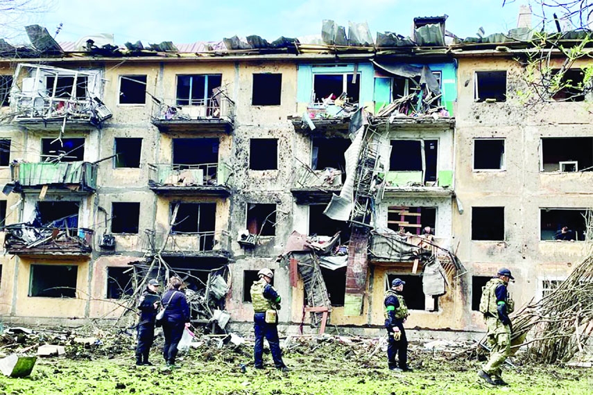 Ukrainian military personnel inspect the site of a missile strike in front of a damaged residential building, amid Russia's invasion, in Dobropillia, in the Donetsk region, Ukraine on Saturday.