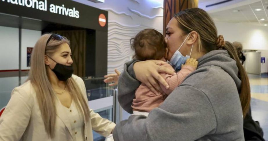 Families embrace after a flight from Los Angeles arrived at Auckland International Airport as New Zealand's border opened for visa-waiver countries Monday, May 2, 2022.