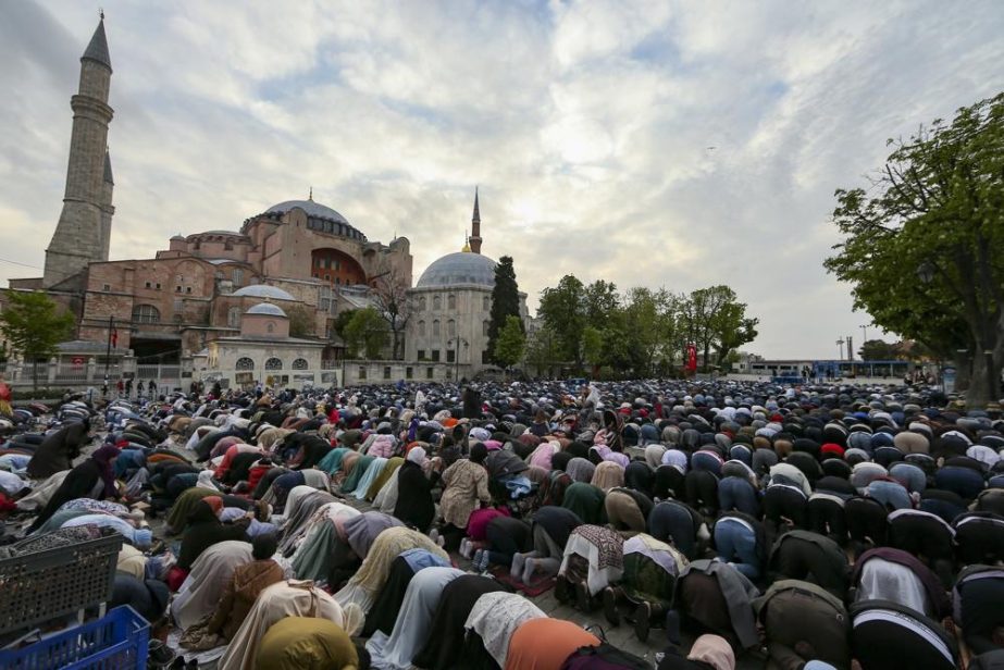 Muslims offer prayers during the first day of Eid al-Fitr, which marks the end of the holy month of Ramadan outside the iconic-historic Haghia Sophia Mosque in Istanbul, Turkey, Monday, May 2, 2022.