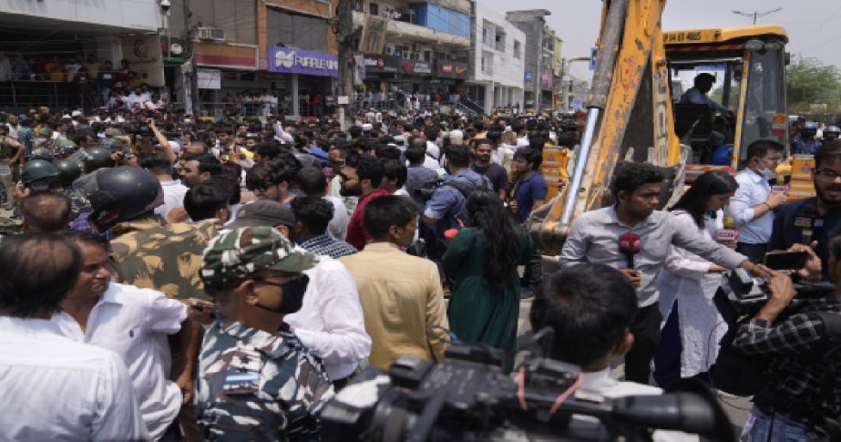 Residents of Shaheen Bagh surround officials during a demolition drive in New Delhi, Monday, May 9, 2022.