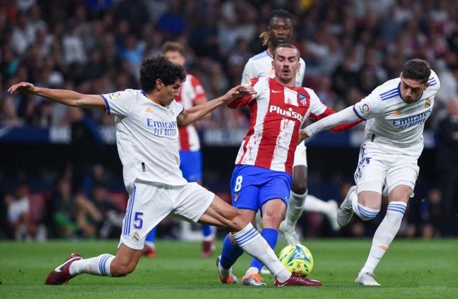 Real Madrid's Jesus Vallejo (left) vies with Atletico de Madrid's Antoine Griezmann (center) during a Spanish La Liga football match in Madrid, Spain on Sunday. Agency photo