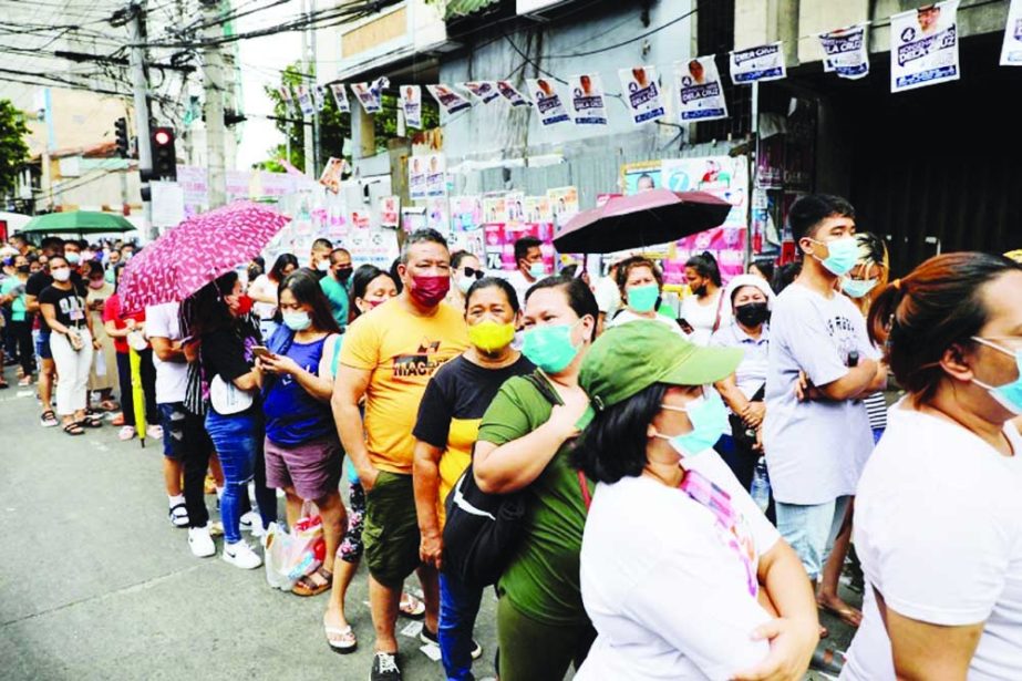 People queue outside a polling precinct to cast their ballots, during the national elections in Tondo, Metro Manila, Philippines on Monday. Agency photo