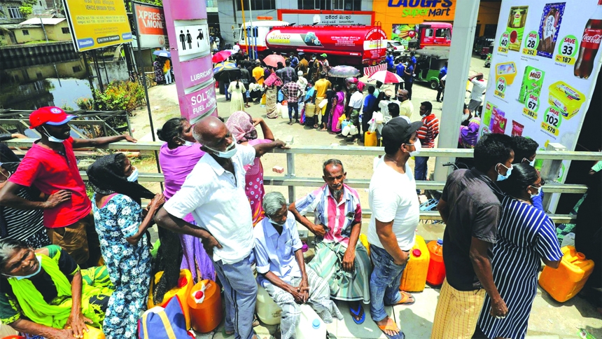 People stand in a long queue to buy kerosene oil for kerosene cookers amid a shortage of domestic gas due to country's economic crisis, at a fuel station in Colombo, Sri Lanka.