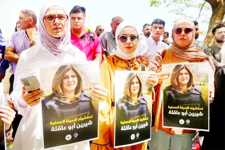 Palestinian women hold pictures of Al Jazeera reporter Shireen Abu Akleh Agency photo