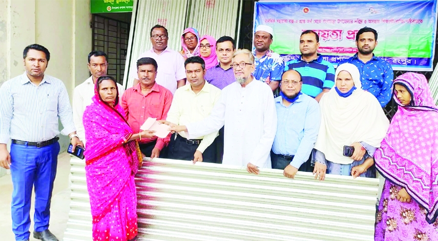 GANGACHARA (Rangpur) : District Administration distributes corrugated iron tins and cash among the poor people at Gnagachara Upazila recently.