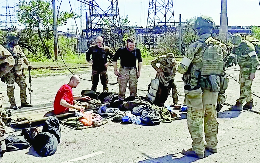 In this photo taken from video released by the Russian Defense Ministry Press Service on Wednesday. Russian servicemen frisk Ukrainian servicemen after they leaved the besieged Azovstal steel plant in Mariupol, Ukraine.