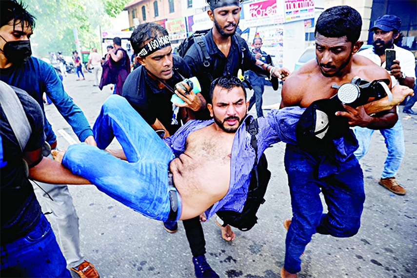 Protesters carry an injured man during a protest organised by students near the President's House in Colombo on Thursday.