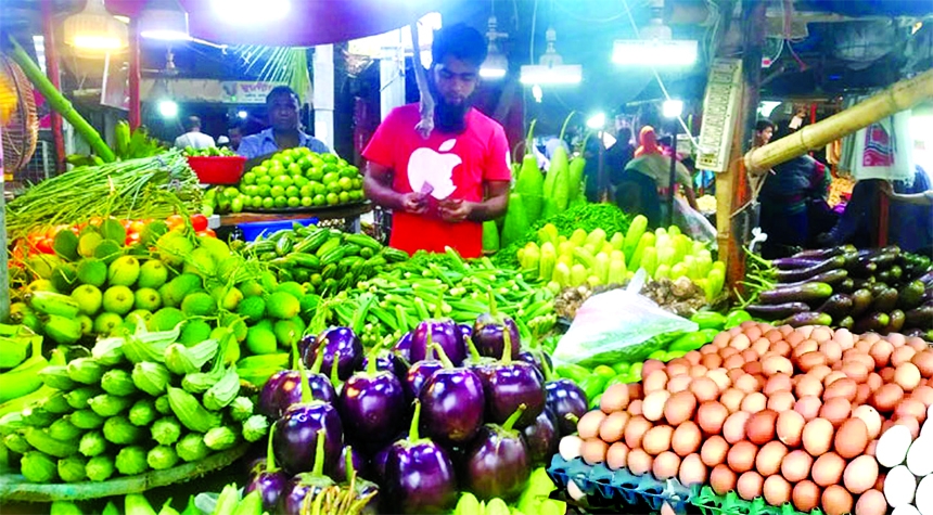 A vegetable vender counts money in his shop in city's Mirpur-11 Kitchen market on Friday amid the price hike of vegetables which went beyond the purchasing capacity of customers.