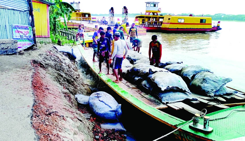 Workers are seen dumping geo-bags at Amrajuri ferry ghat in the estuary of Sondhu and Gabkhan River at Kaukhali upzila of Pirojpur district on Thursday to protect erosion.