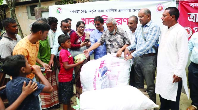Mayor of Sylhet City Corporation Ariful Haque distributes dry foods among the flood victims organized by Gonoswashtho Kendro on Friday.