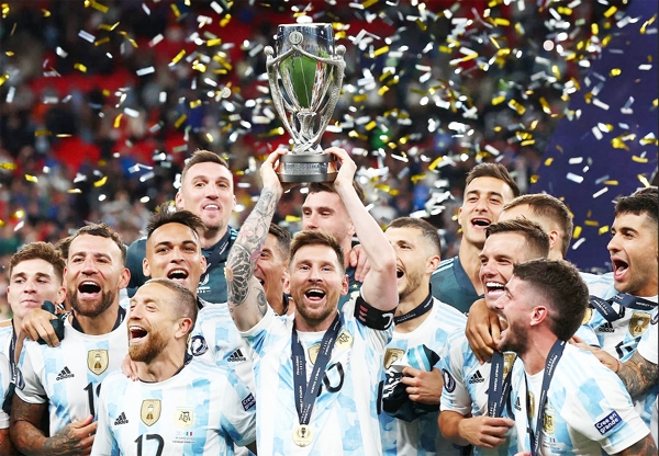 Argentina's striker Lionel Messi lifts the trophy as Argentina players celebrate on the pitch after their victory in the 'Finalissima' International friendly football match against Italy at Wembley Stadium in London on Wednesday.