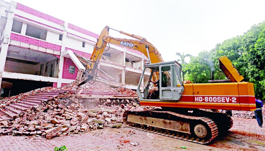 A hydraulic crane demolishes the old building of Sufia Kamal National Public Library in the city's Shahbagh area on Thursday.