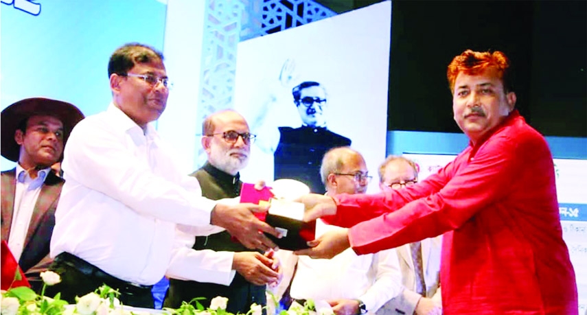 Amirul Islam, a farmer of Tanmoy Dairy Farm in Ishwardi receives the 'Dairy Icon' Award -2022 at the Krishibid Institution Bangladesh (KIB) Convention Hall at Khamarbari in the capital recently.