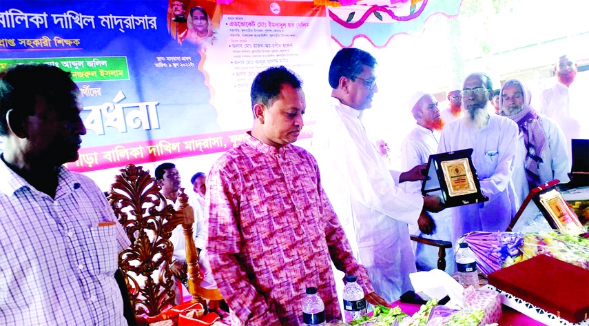 FULBARIA (Mymensingh) : Adv Emdadul Huq Salim,President, Awami League of Fulbaria Upazila Unit gives crest to the retired teachers of Koiyarchala Purbopara Balika Dakhil Madrasa at Madrasa premises at a farewell on Thursday .