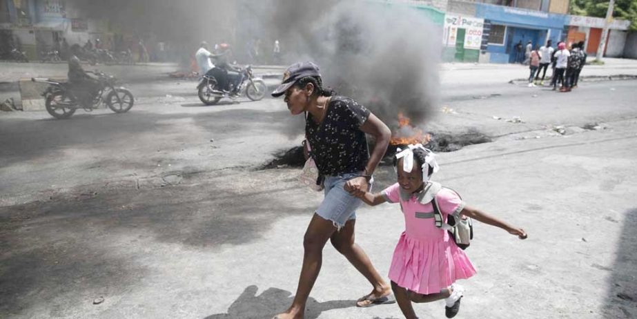 Gunman hosting a child in Haiti. Agency photo