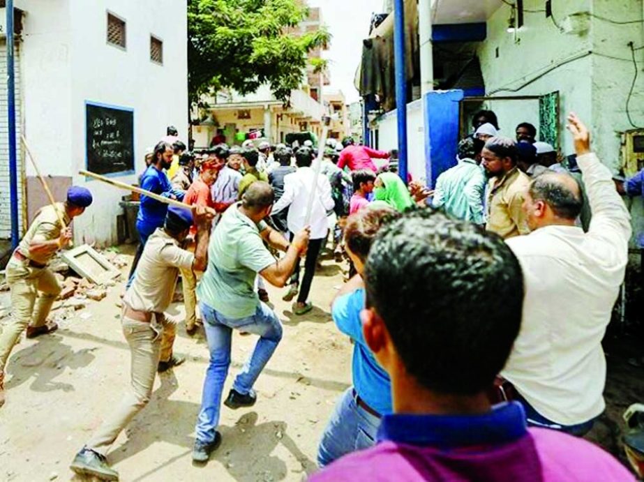 Police personnel chase away people during their protest demanding arrest of former BJP spokesperson Nupur Sharma, in Ahmedabad on Monday. Agency photo