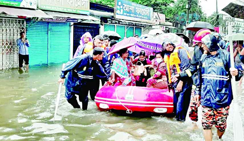 Fire service personnel evacuate local people at flood-prone area with Gemini board as many low-lying areas submerged due to onrush of hilly water. This photo was taken from VIP road in Sylhet on Saturday.