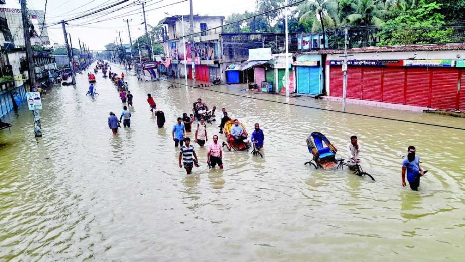 People wade through a submerged road in Sylhet on Sunday as the country’s metropolitan city has been ravaged by massive flood, triggered by an onrush of waters from upstream India’s northeastern states –Assam and Meghalaya. NN Photo