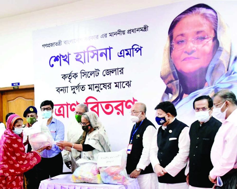 Prime Minister Sheikh Hasina distributes relief items to flood victims after a view exchange meeting with public representatives, high government officials and local political leaders at Sylhet Circuit House on Tuesday. PID photo