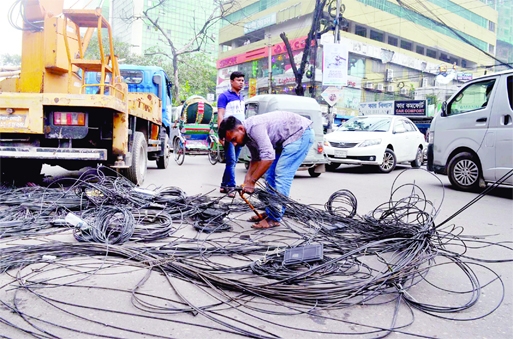 Electricians of Dhaka South City Corporation are seen disconnecting web of illegal Internet cables in city's Bijoynagar area on Thursday, as there was possibility of fire hazard due to short circuit in the rainy day.